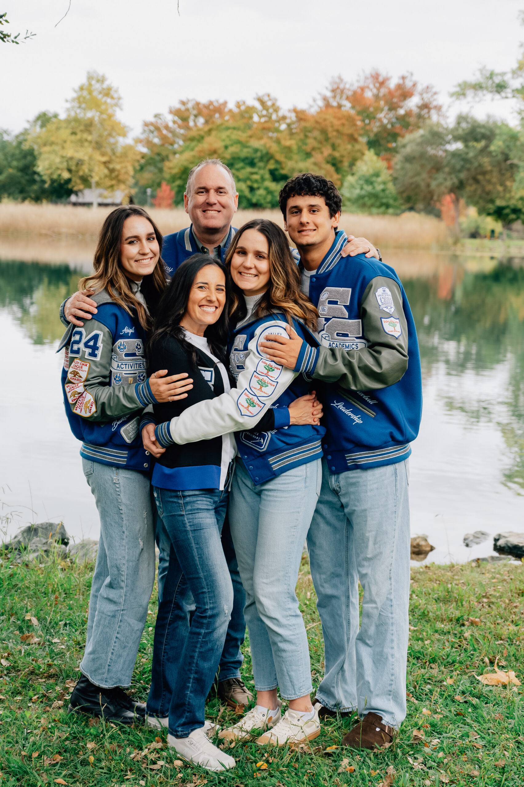 Family of five wearing school letterman jackets during a Lodi Lake family portrait session