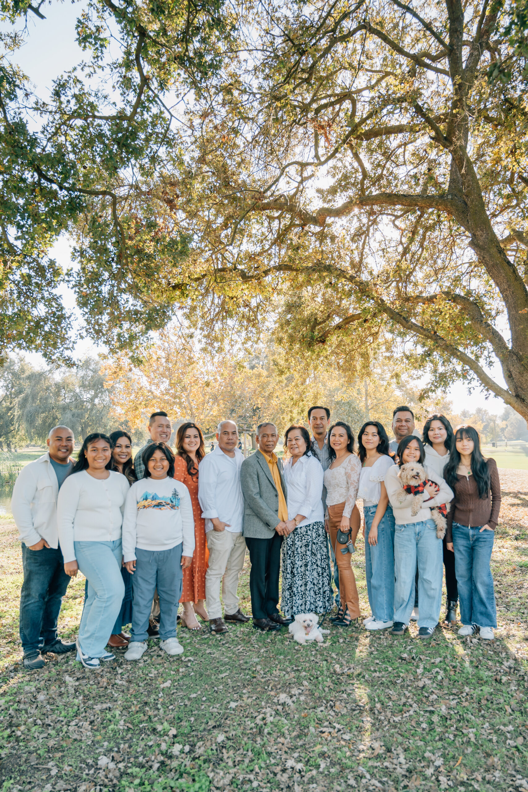 Extended family portrait at Oak Grove Park in North Stockton with multiple generations smiling together in fall light