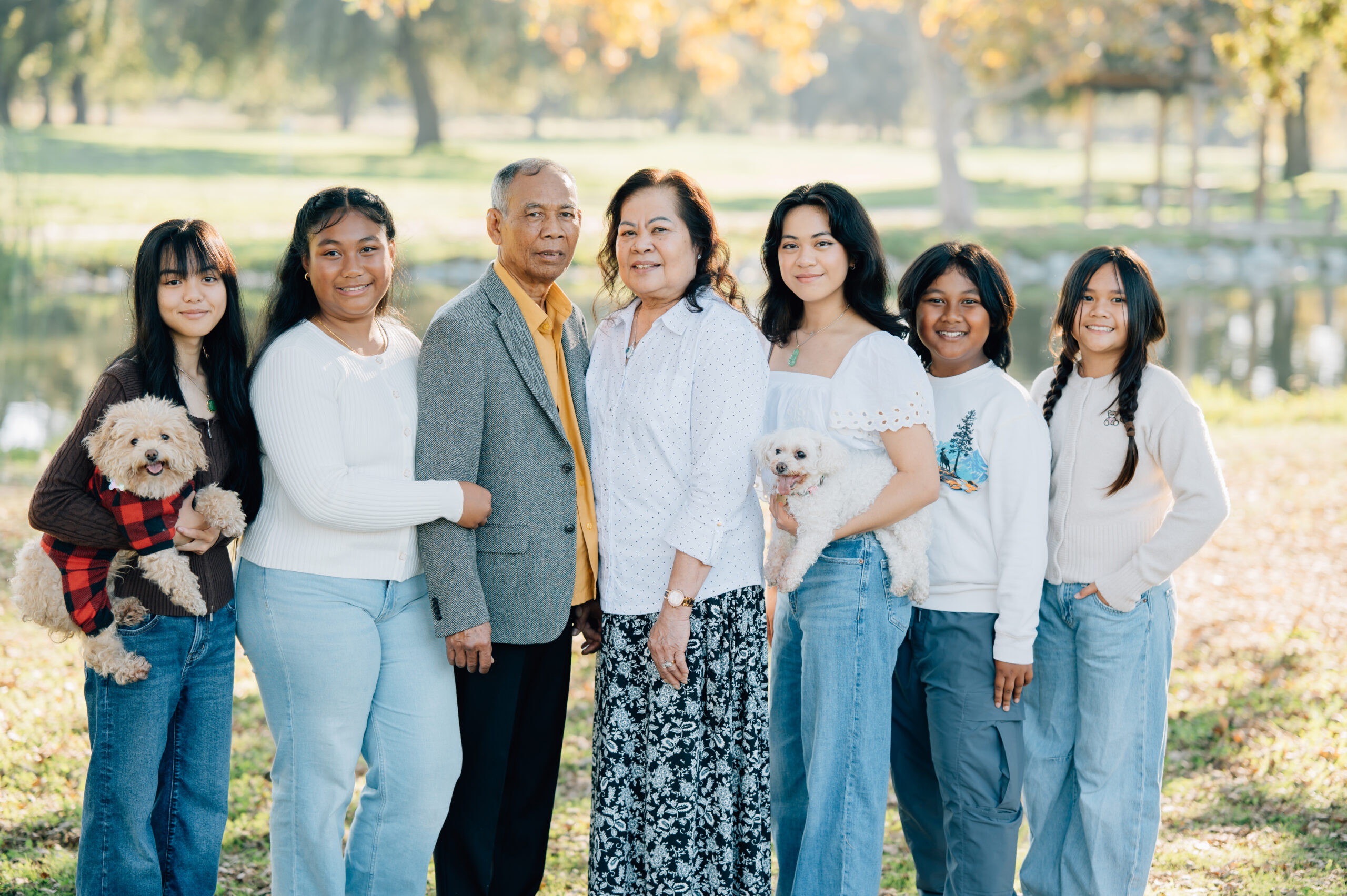 Extended family portrait at Oak Grove Park in North Stockton with grandparents and grandkids smiling together in fall light