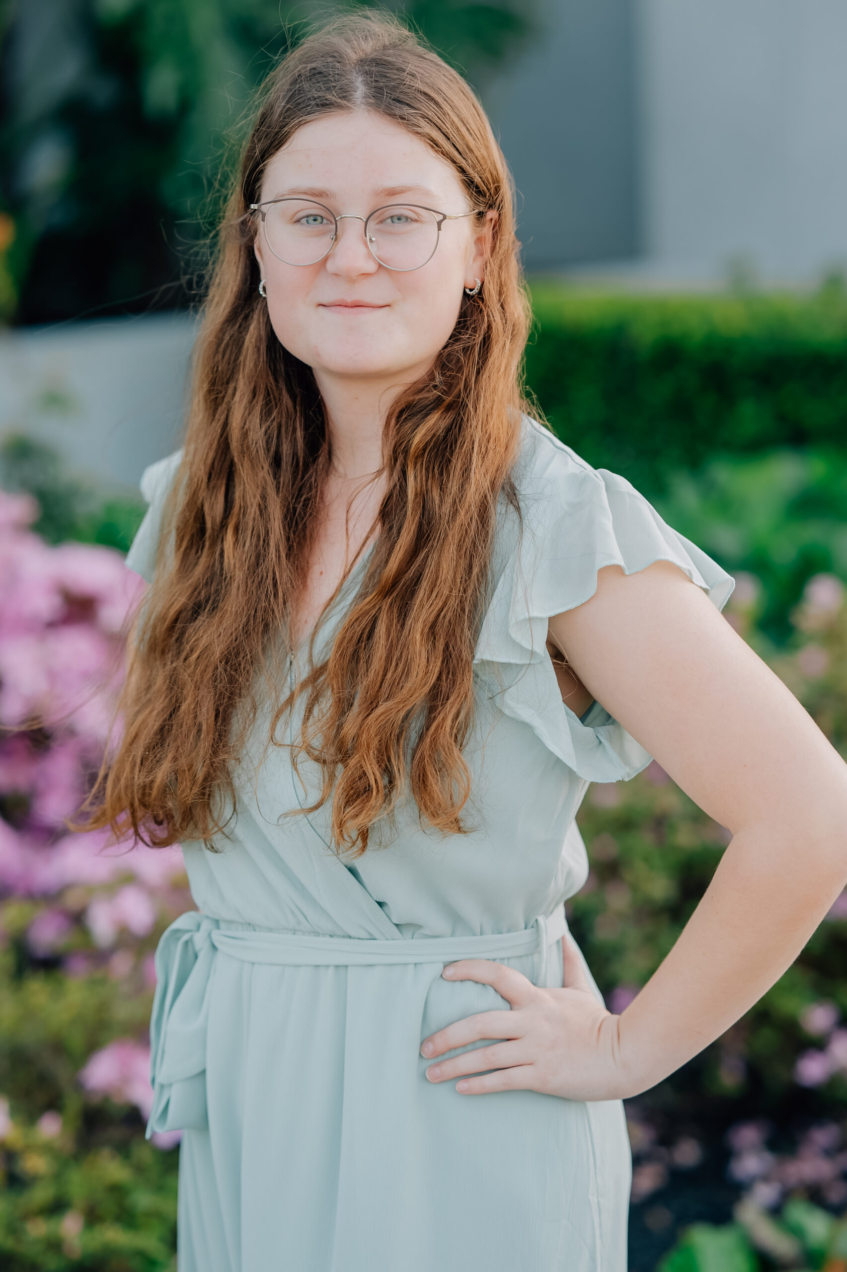 High school senior portrait at the Oakland Temple featuring soft greenery and natural light.