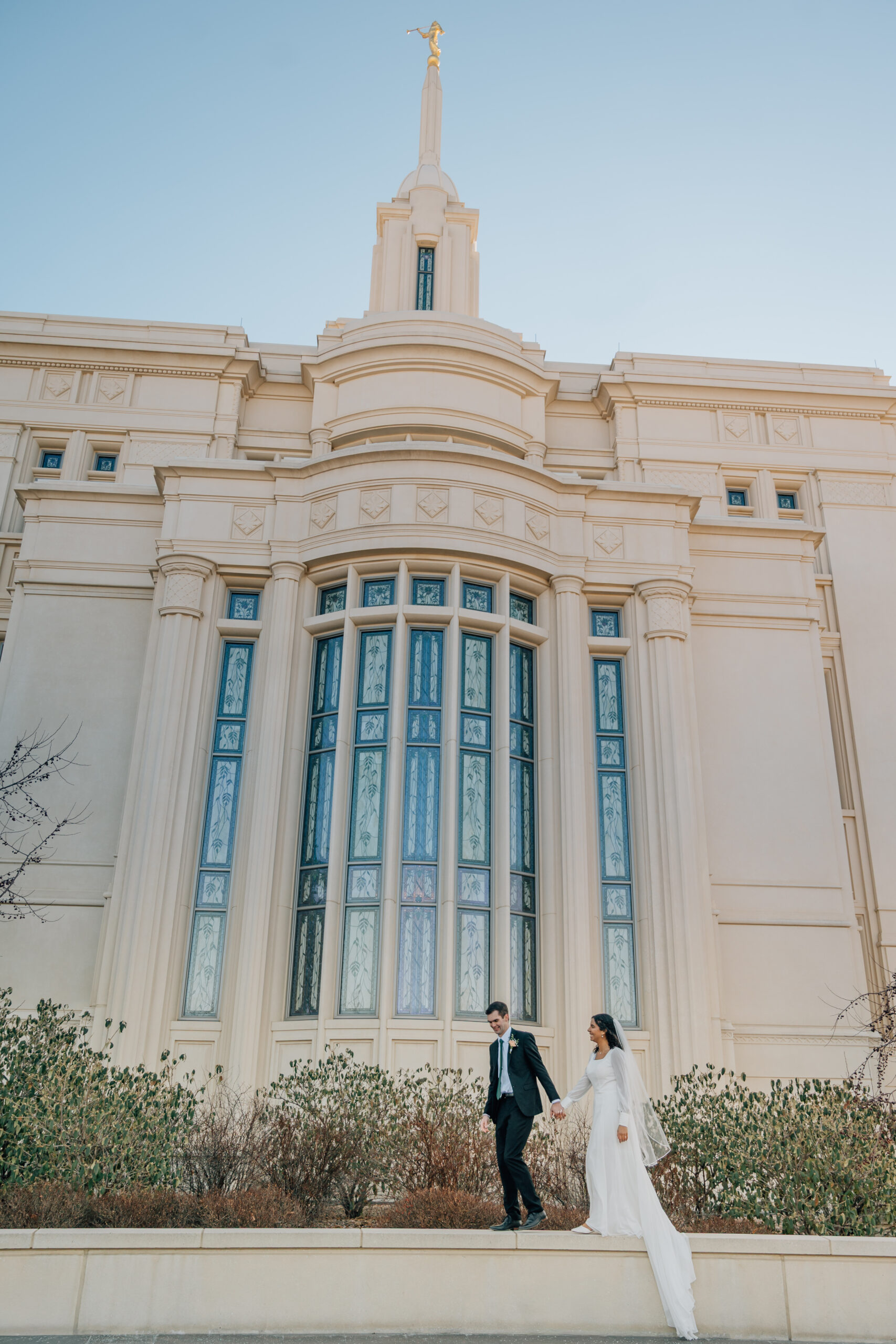 Newlywed couple walking together outside the Payson Utah Temple