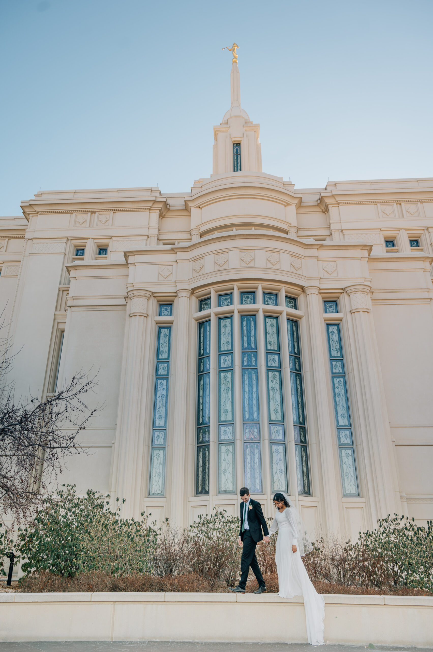 Newlywed couple walking together outside the Payson Utah Temple