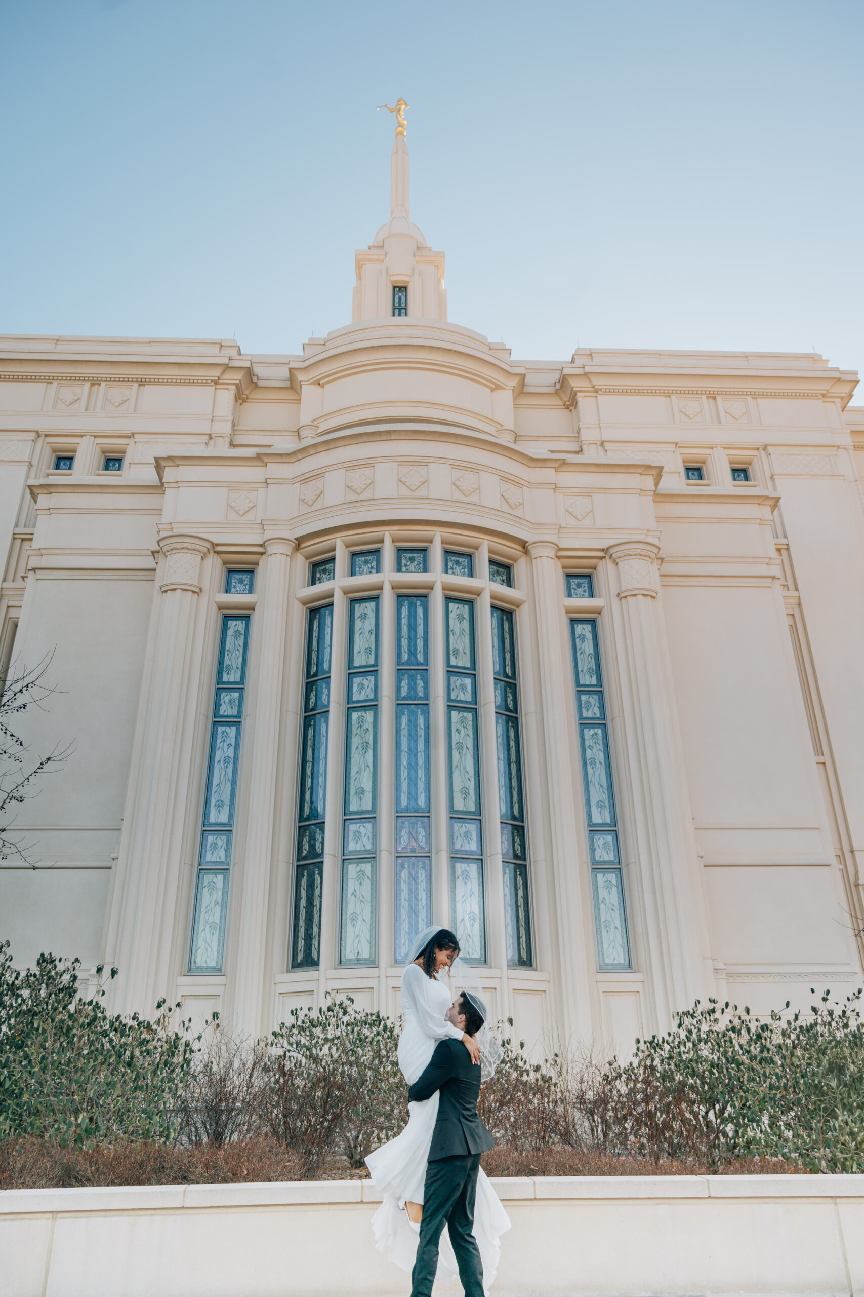 Newlywed couple walking together outside the Payson Utah Temple