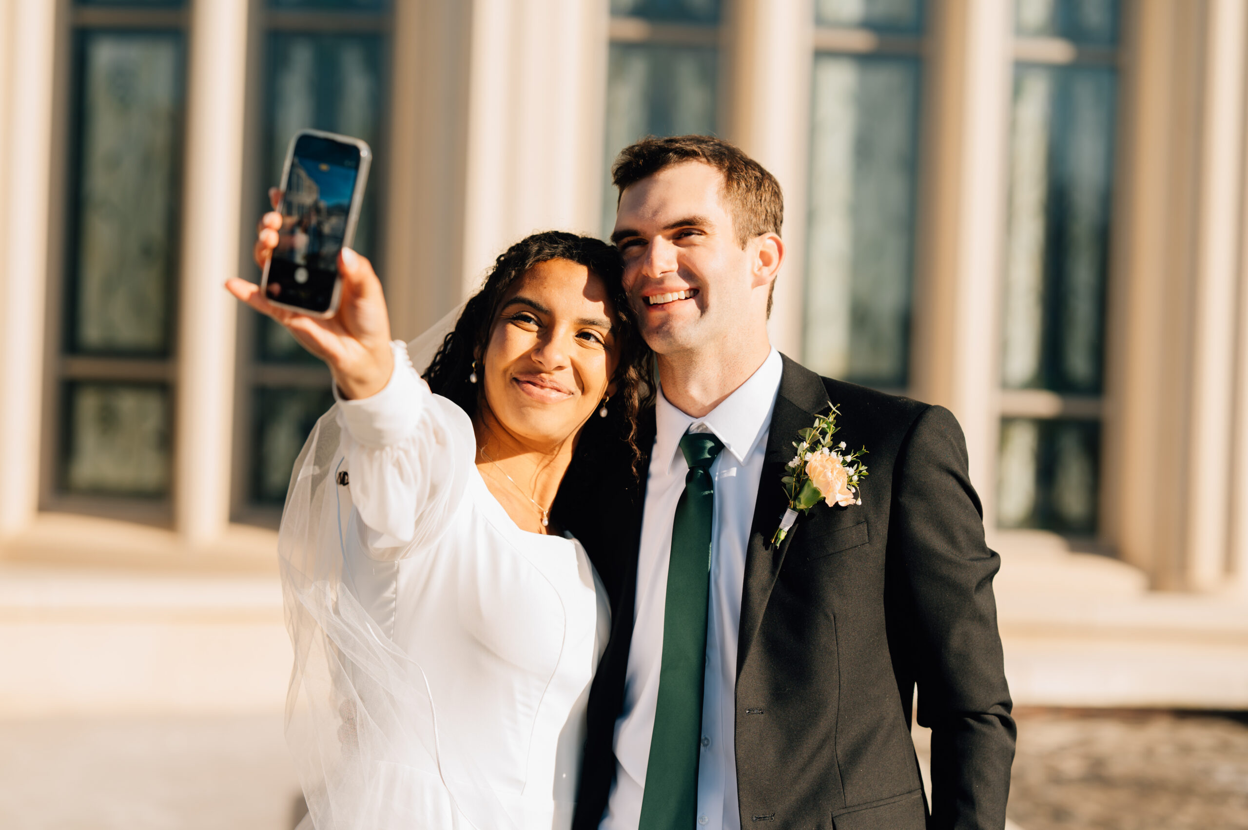 Bride and groom taking a selfie outside of the Payson Utah LDS Temple