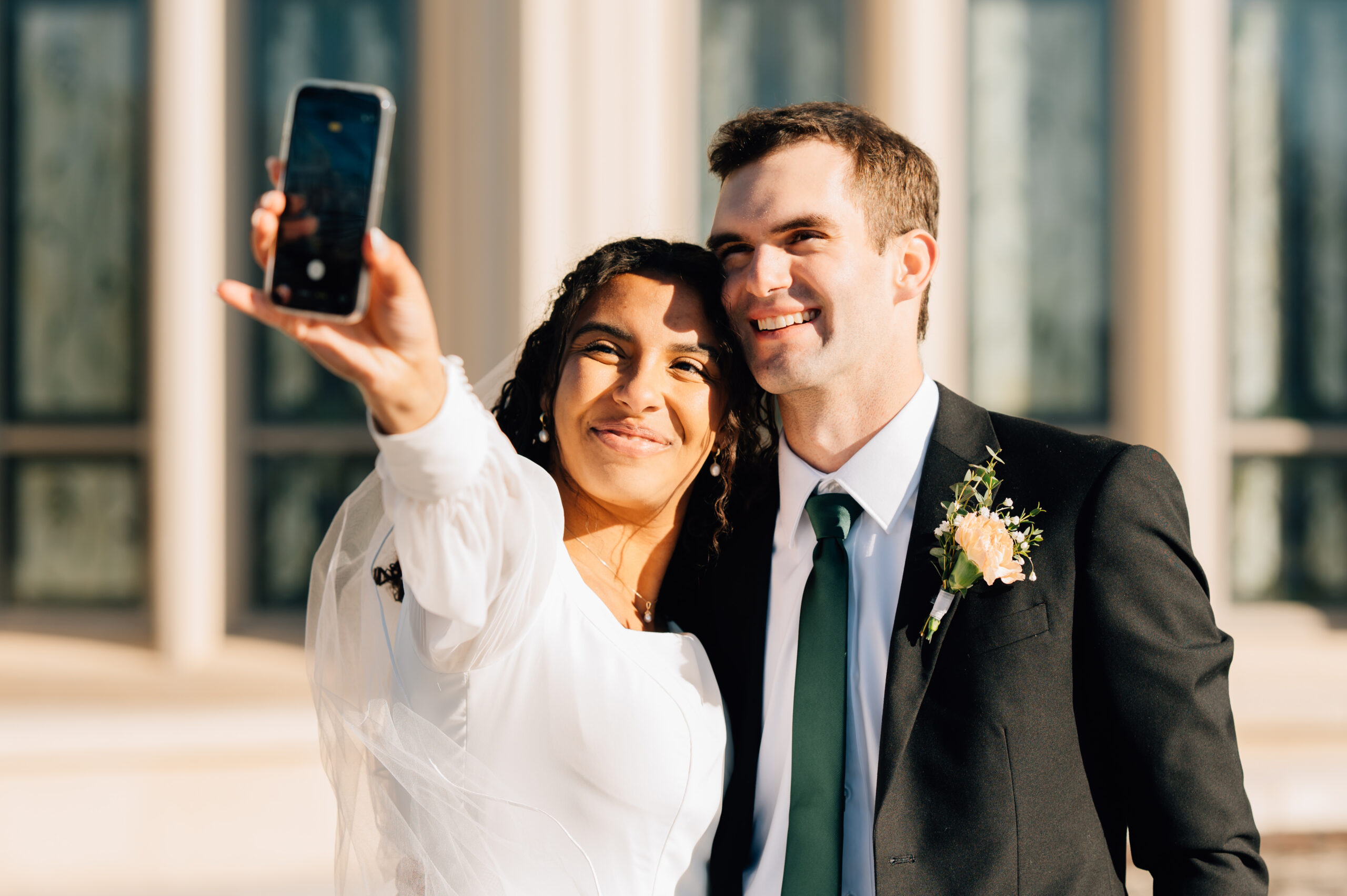 Bride and groom taking a selfie outside of the Payson Utah LDS Temple