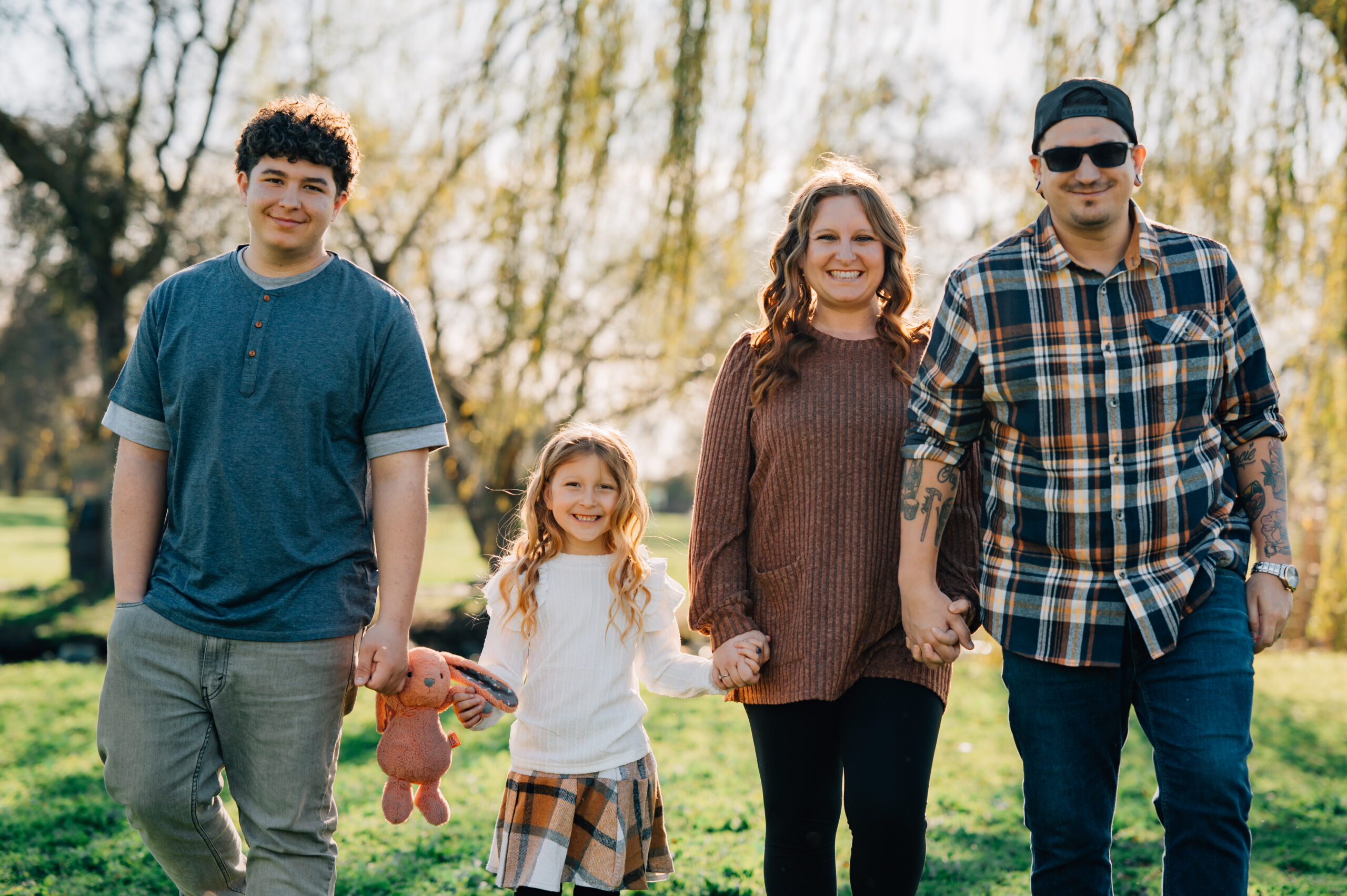 family holding hands walking across grassy field