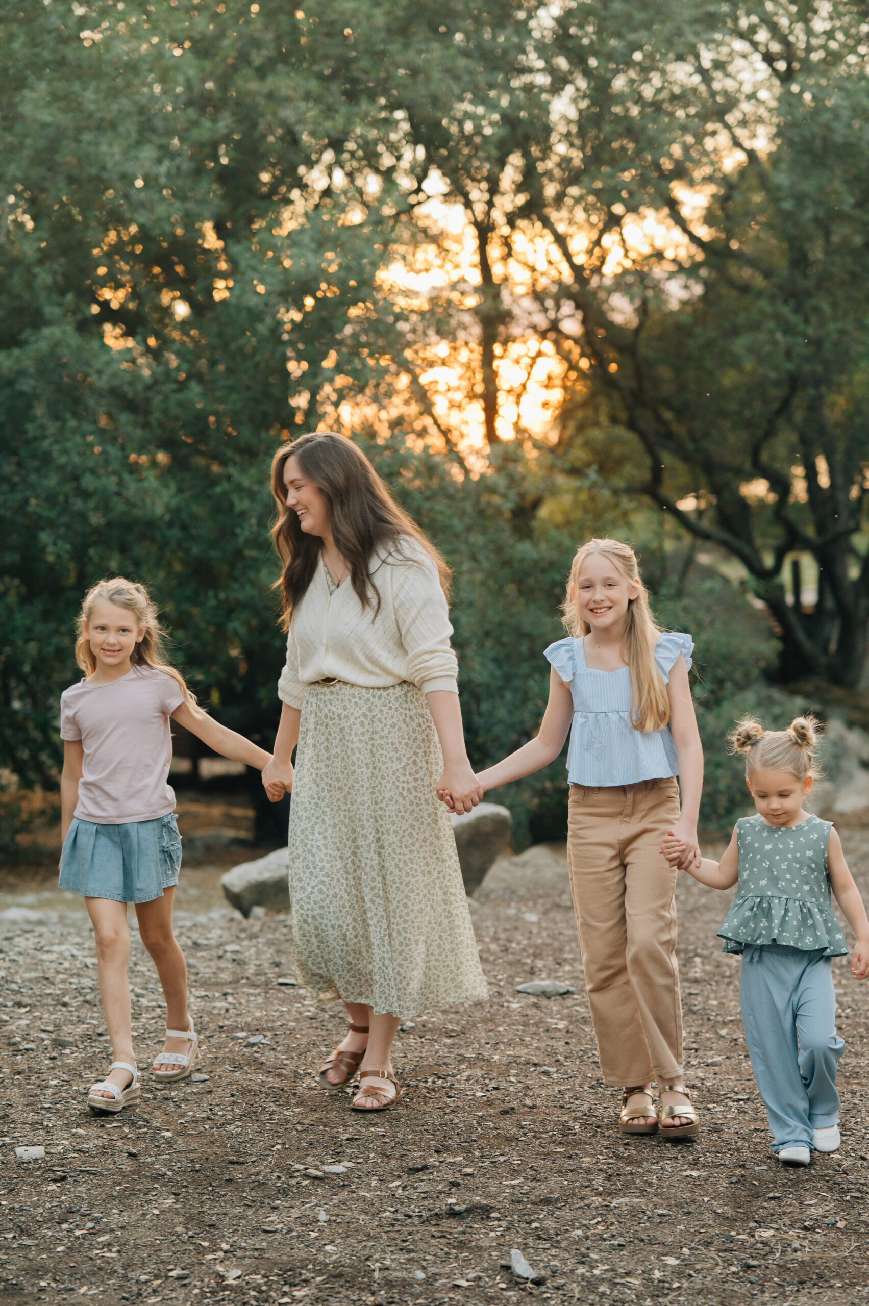 Mom and three daughters walking together during a natural outdoor family session in Rocklin CA