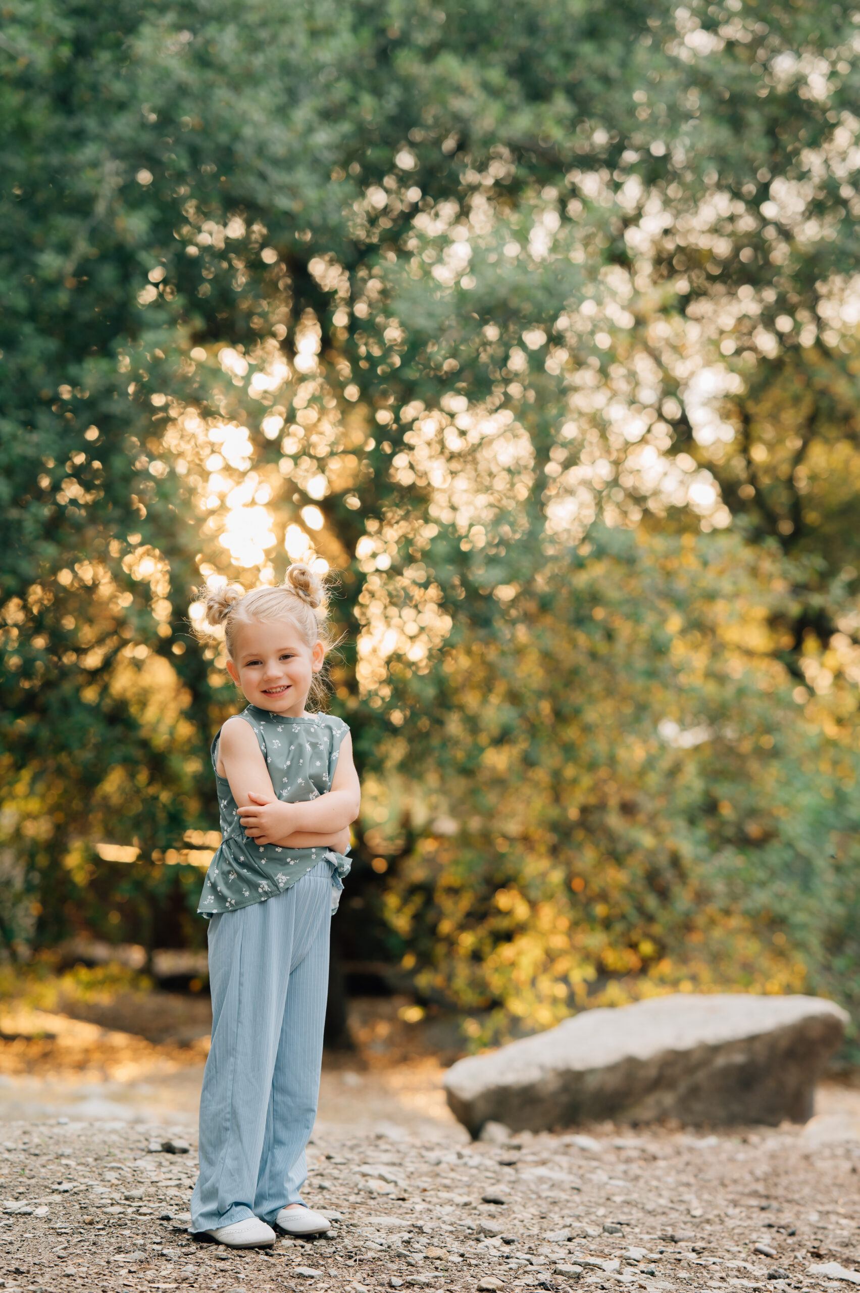 A portrait of a young girl folding her arms during a playful outdoor family session