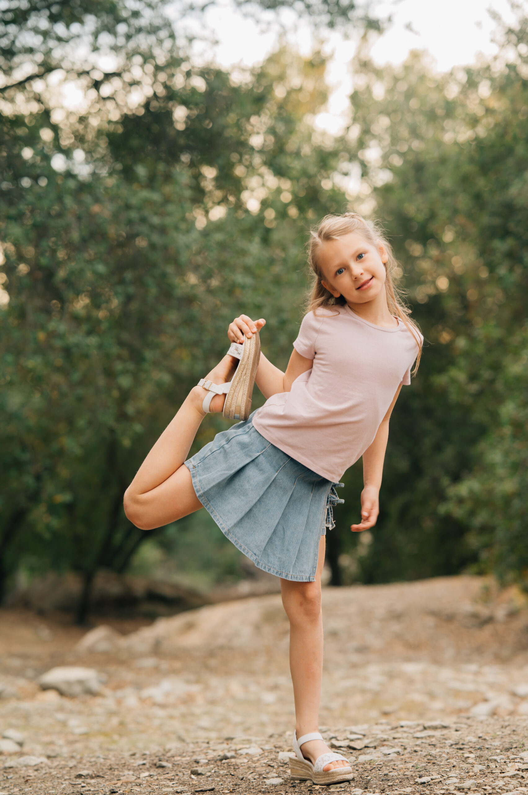 A portrait of a young girl dancing  during a playful outdoor family session