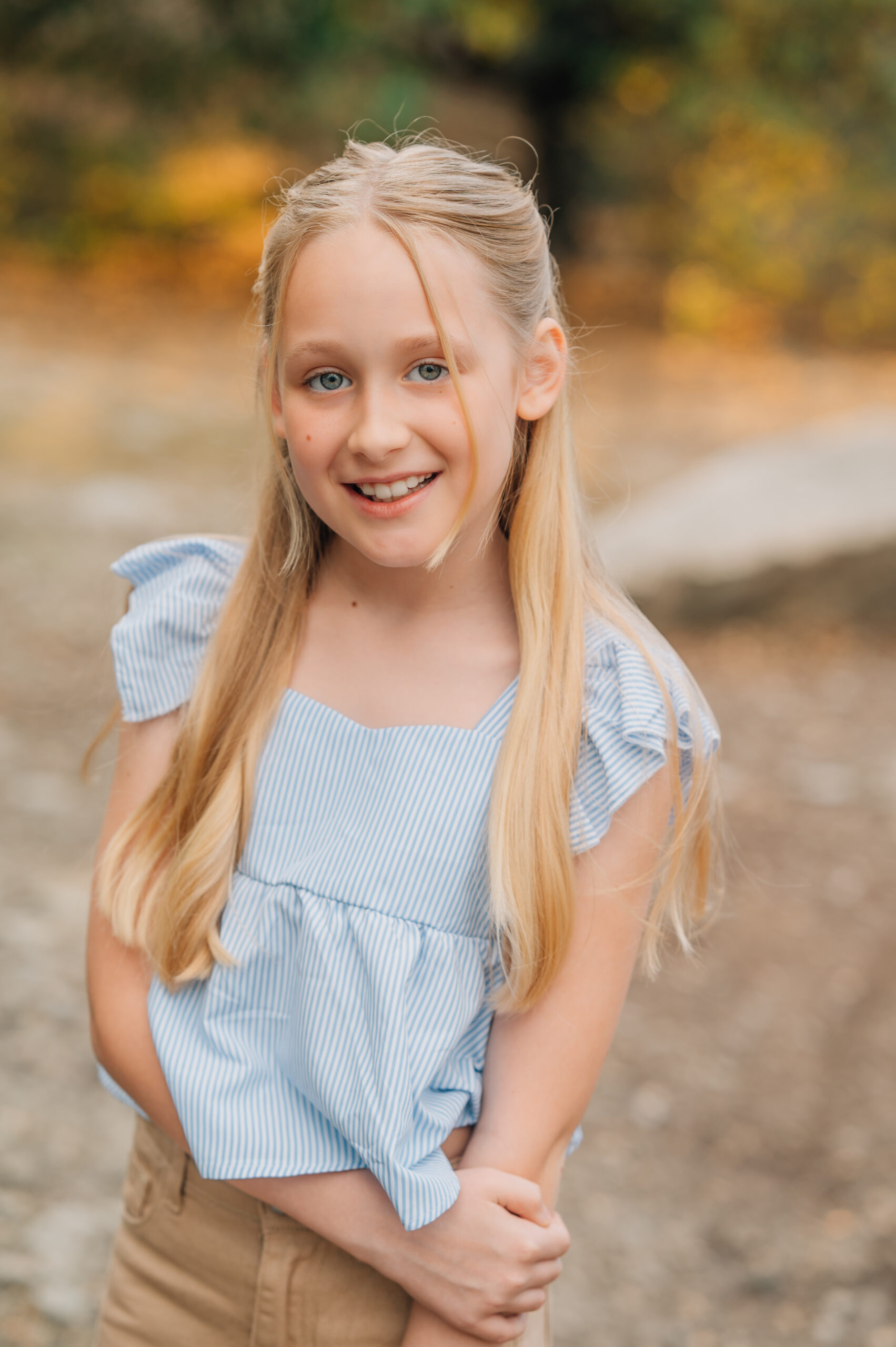 Close-up portrait of a young girl covering one eye during a playful outdoor family session