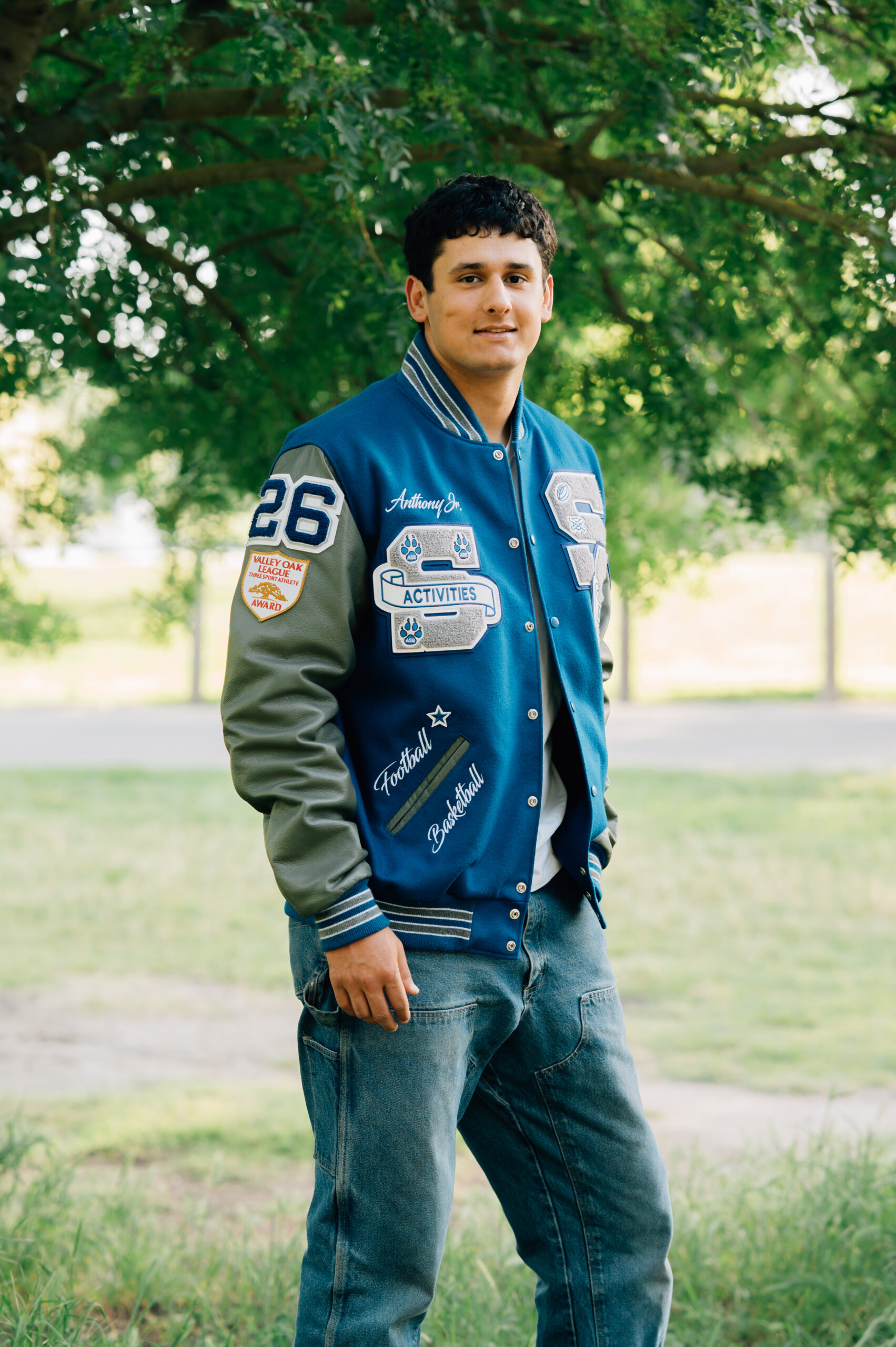 Senior boy standing beneath a tree at Shumway Oak Grove Park in Stockton 