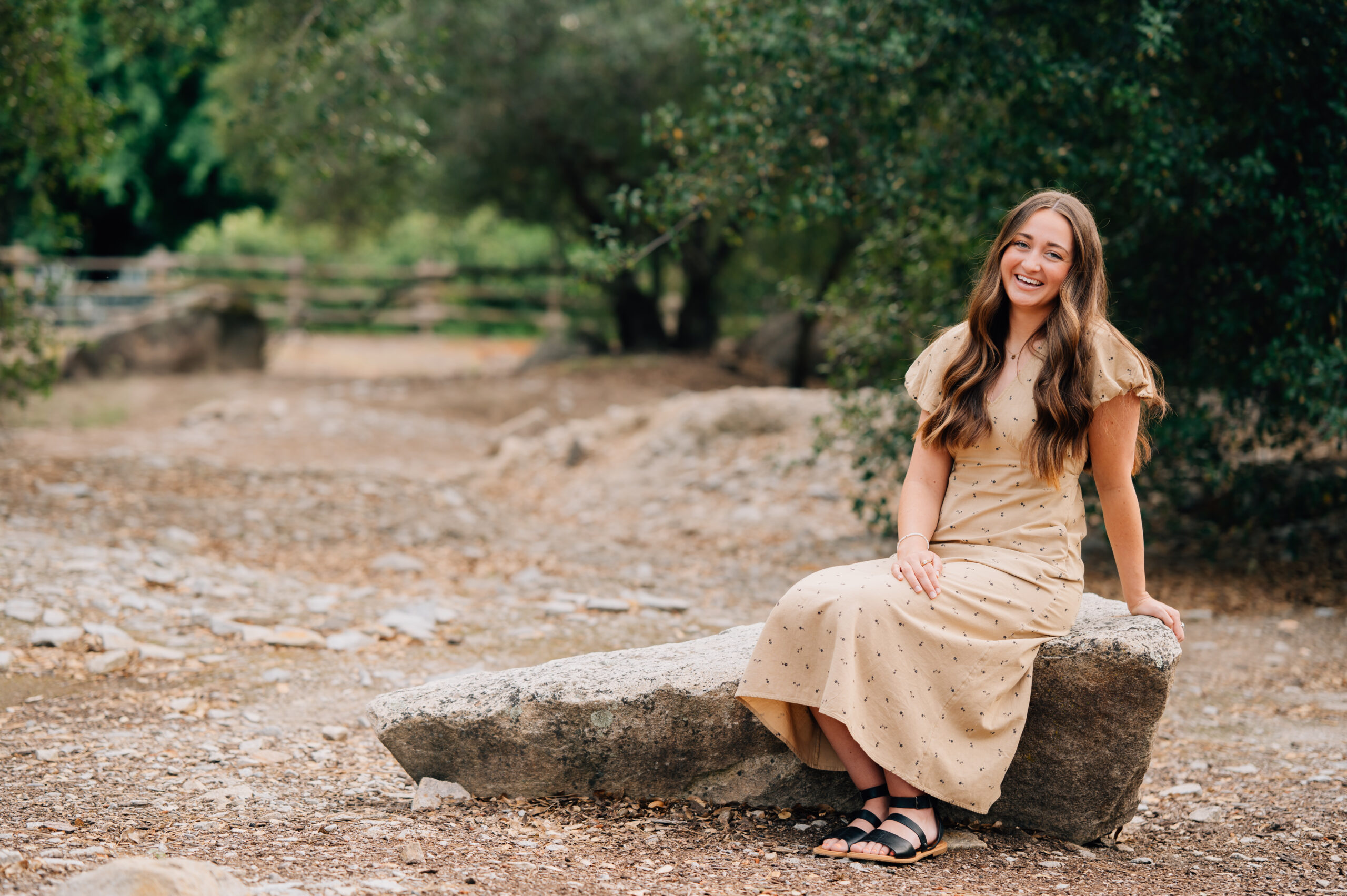 Portrait of Young Woman sitting on rock during outdoor photo session in Rocklin CA