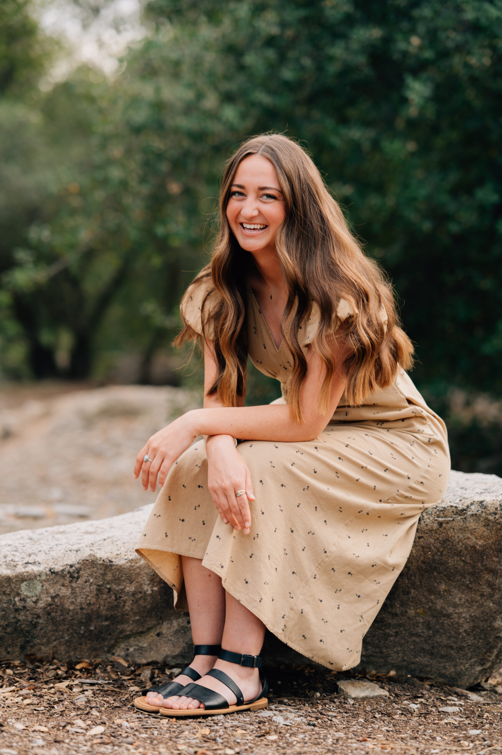 Portrait of Young Woman sitting on rock during outdoor photo session in Rocklin CA