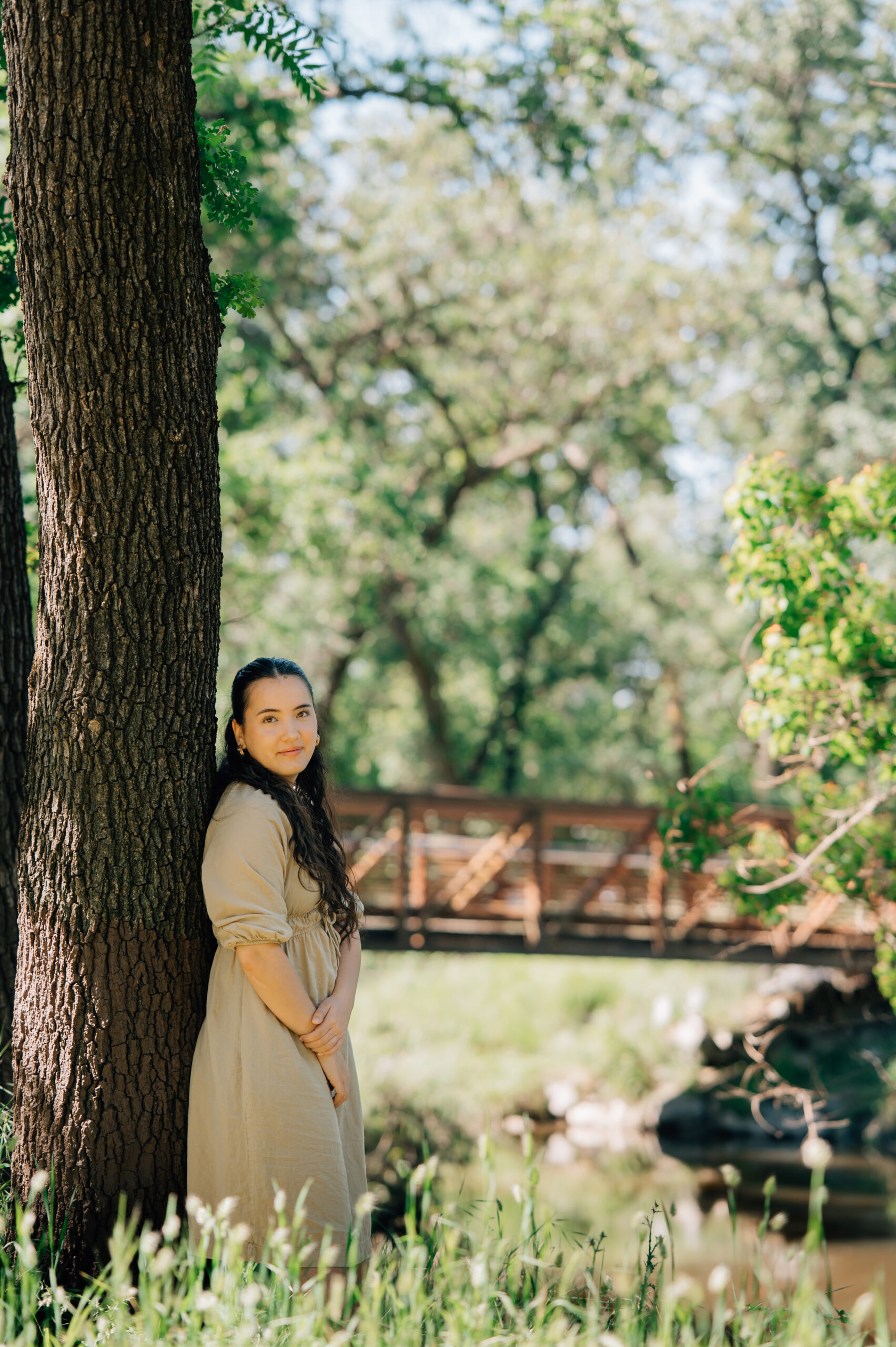Senior portrait in soft neutral dress beside creek in Rocklin California