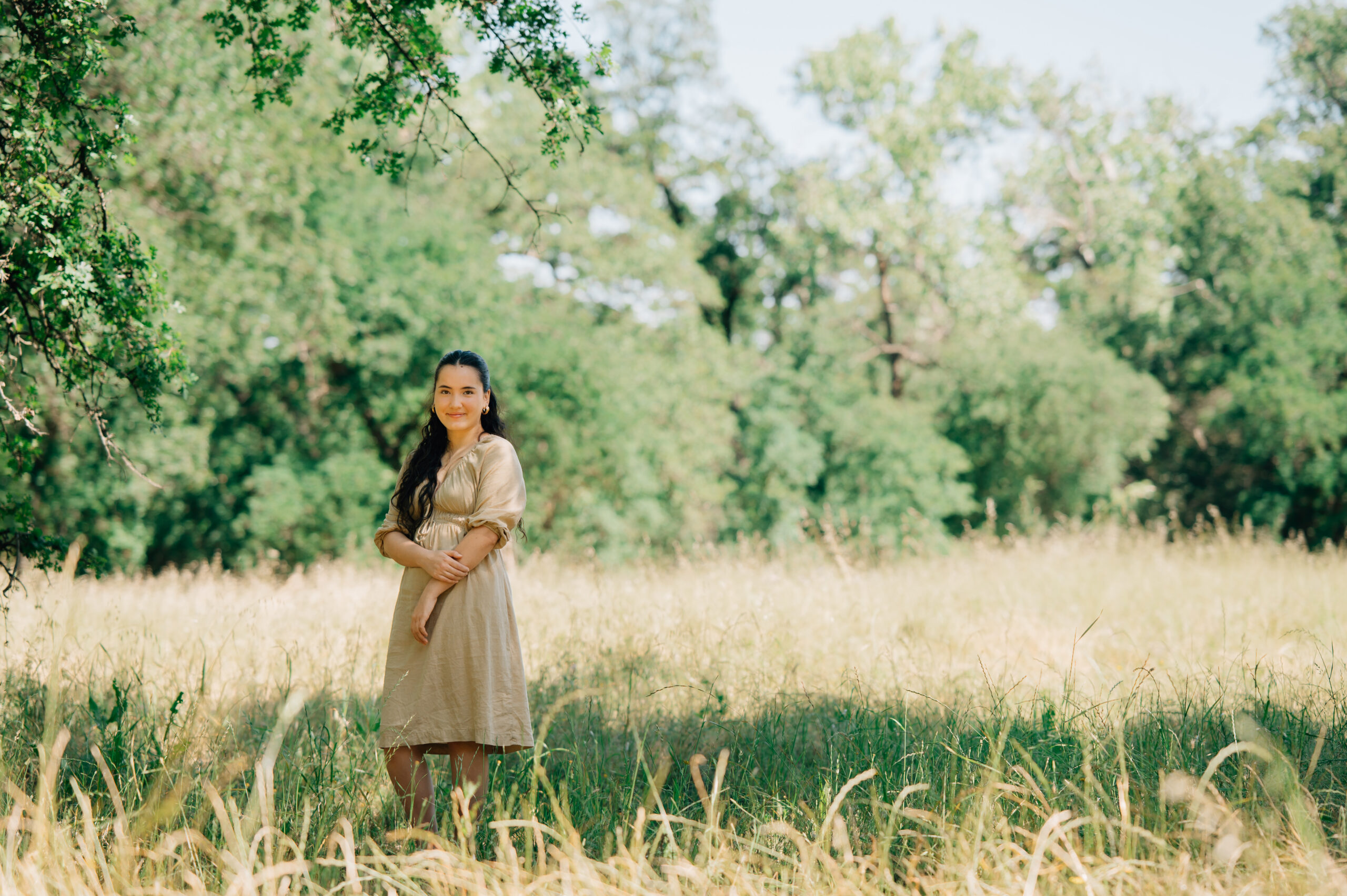 Outdoor senior session in golden grass field with oak trees in Northern California