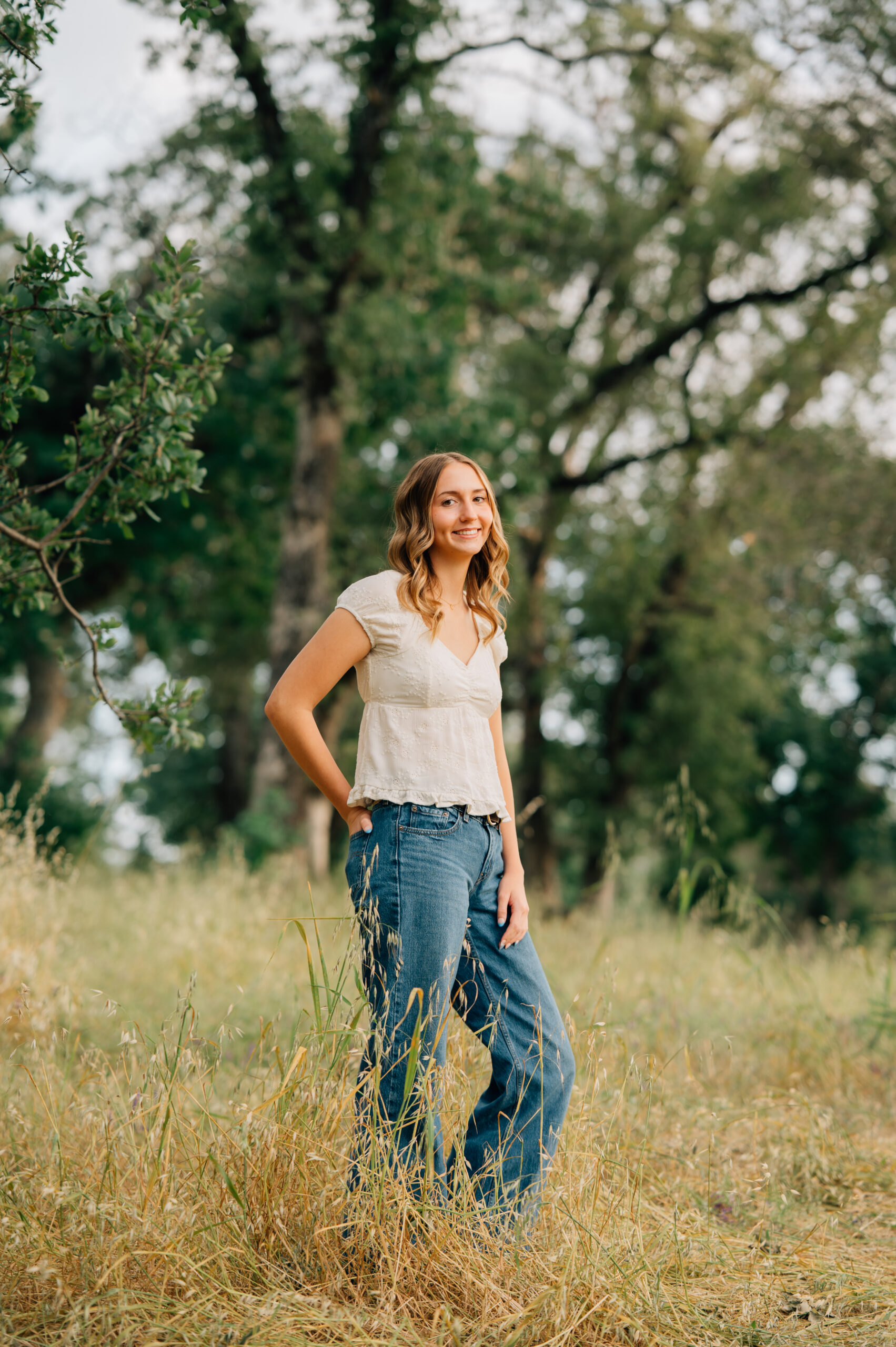 Senior girl standing in tall golden grass at Griffith Quarry Park in Penryn during a Northern California senior session.