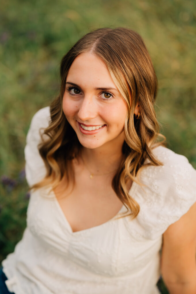 Close-up senior portrait of high school graduate smiling in soft golden evening light at Griffith Quarry Park.