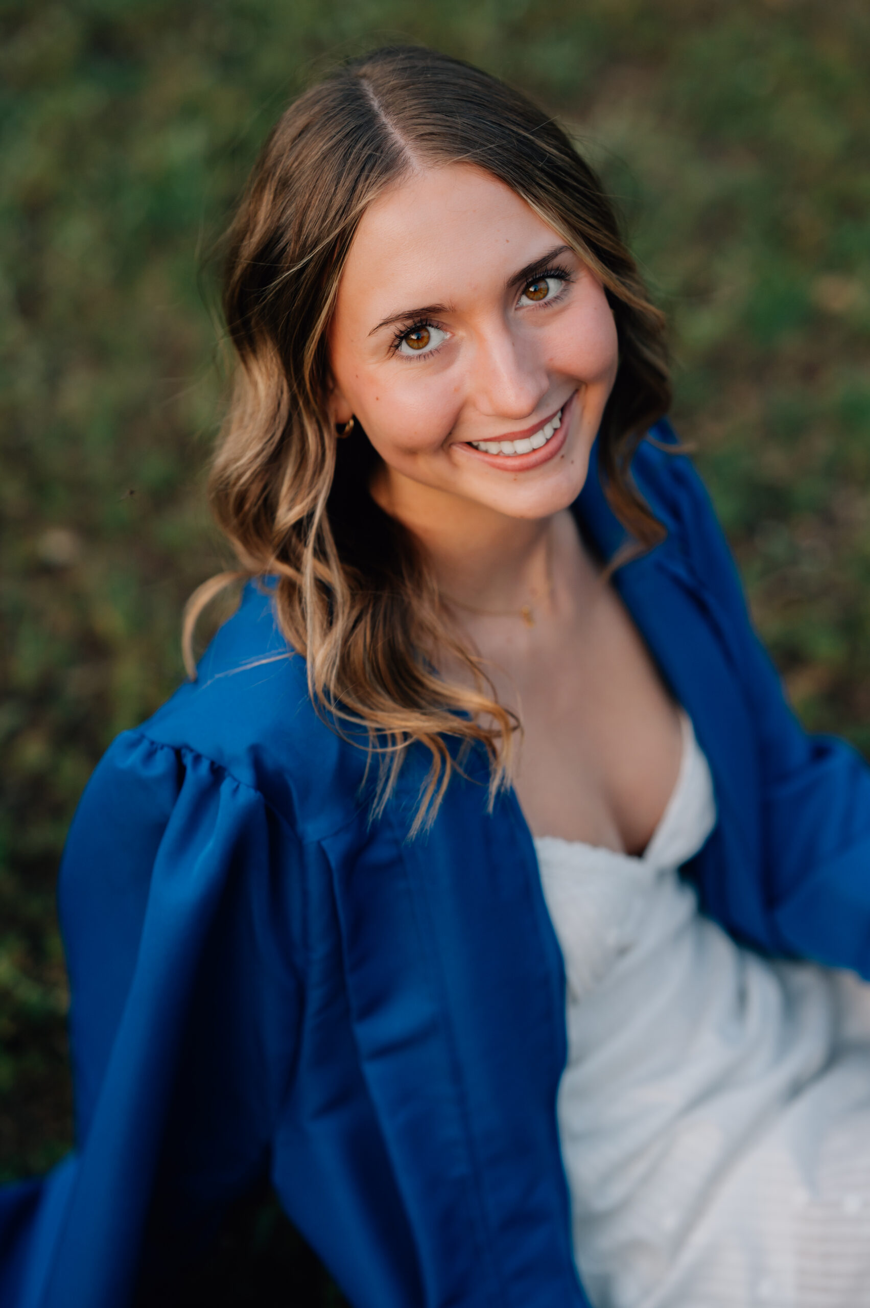 Close-up senior portrait of high school graduate smiling in soft golden evening light at Griffith Quarry Park.