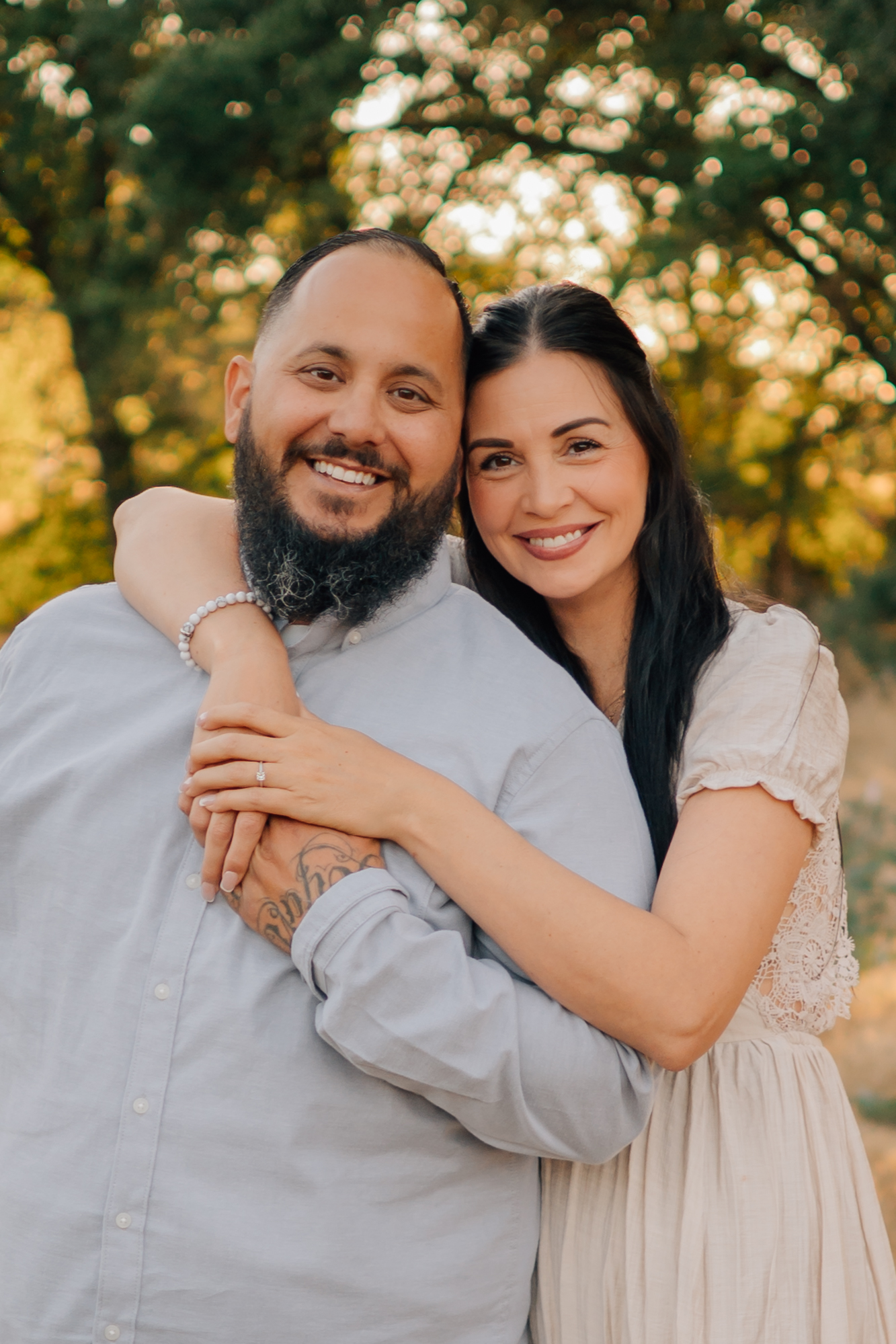 Close portrait of a smiling husband and wife embracing outdoors during golden hour in Ripon.