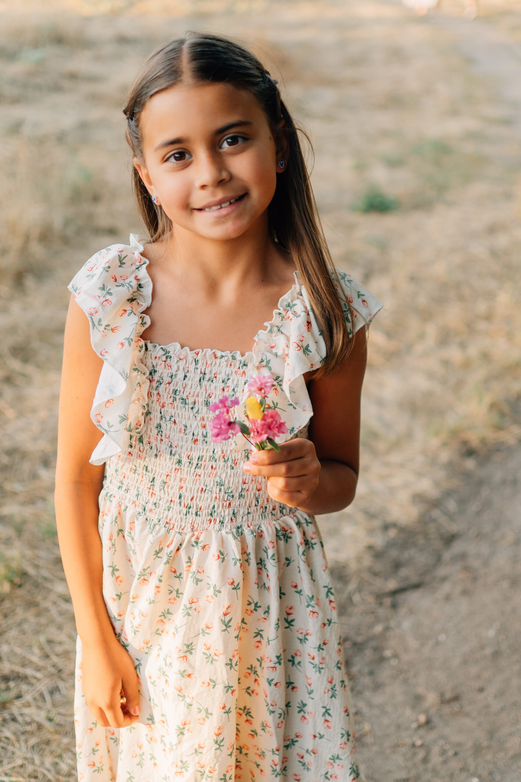 Little girl picking flowers during extended family session at Oak Grove Park