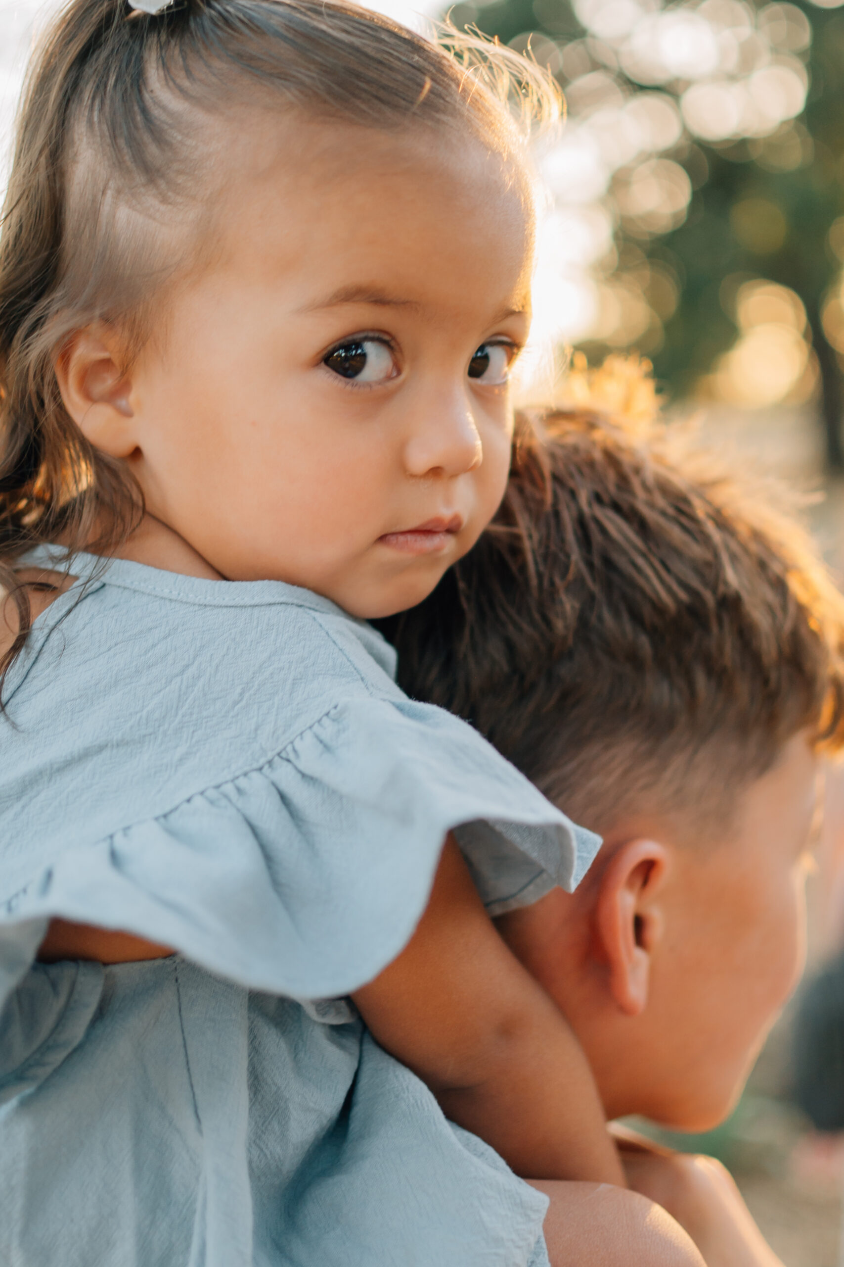 Older siblings holding toddlers and babies during a warm, candid family photo session.