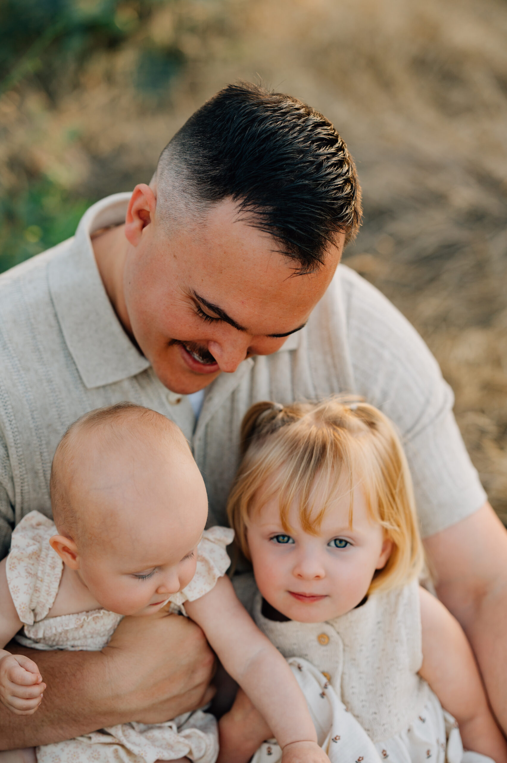 Father spending time with his three daughters during a family photography session at Oak Grove Park.