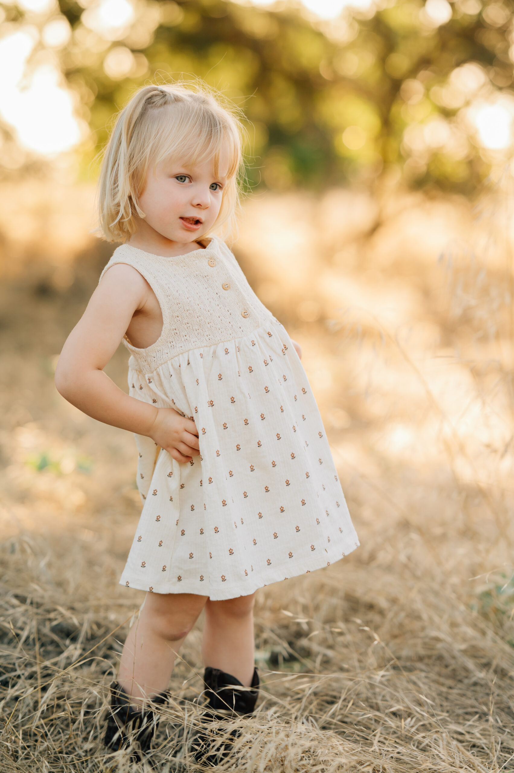 Young girl smiling at the camera during a family photo session at Oak Grove Park in Ripon.
