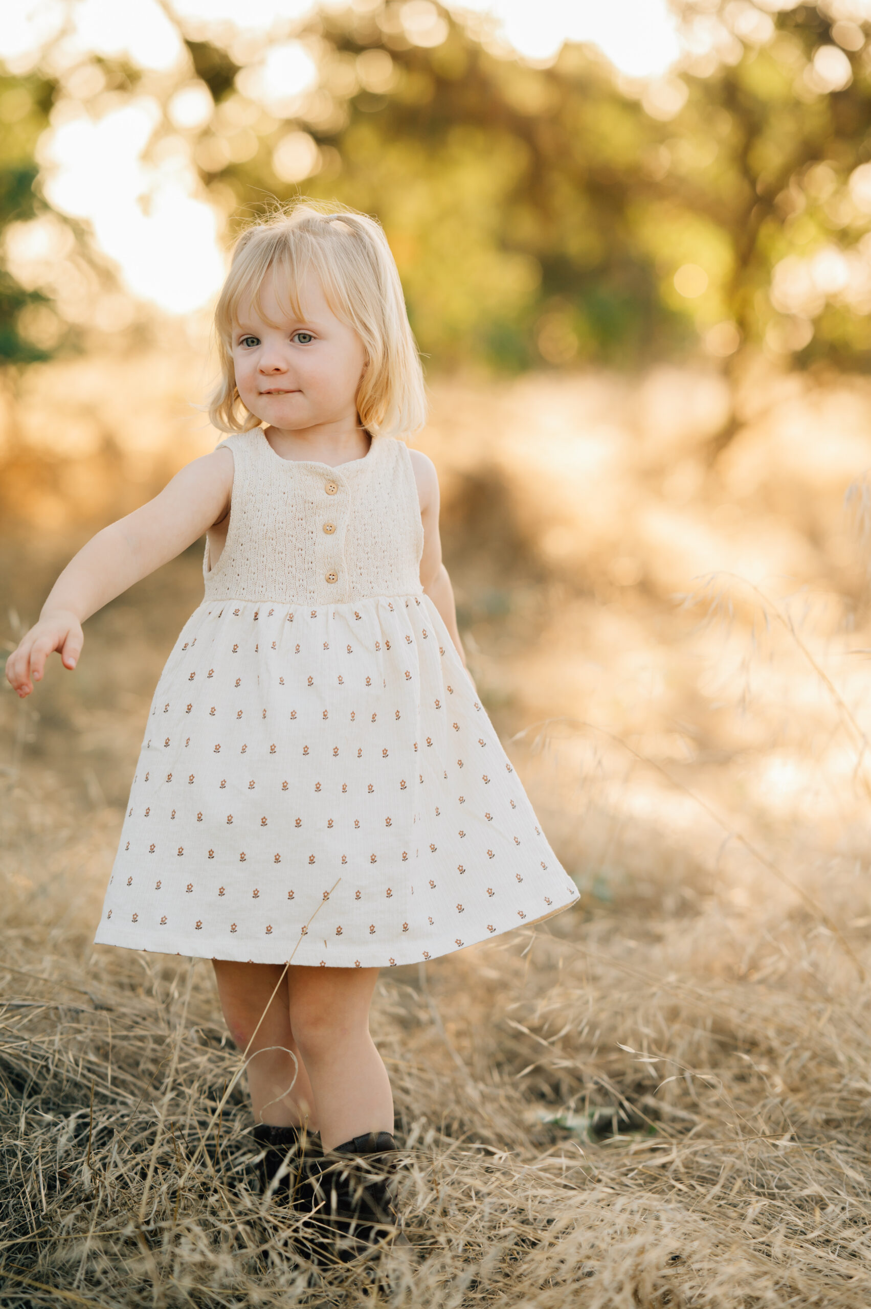 Young girl smiling at the camera during a family photo session at Oak Grove Park in Ripon.