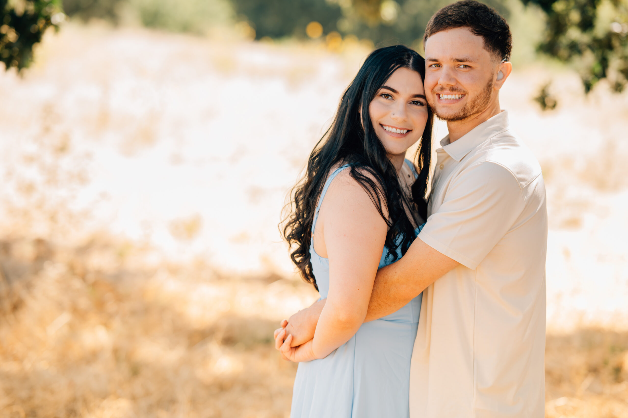 Darling couple arm in arm as they smile during an extended family session at Army Corps Park. 