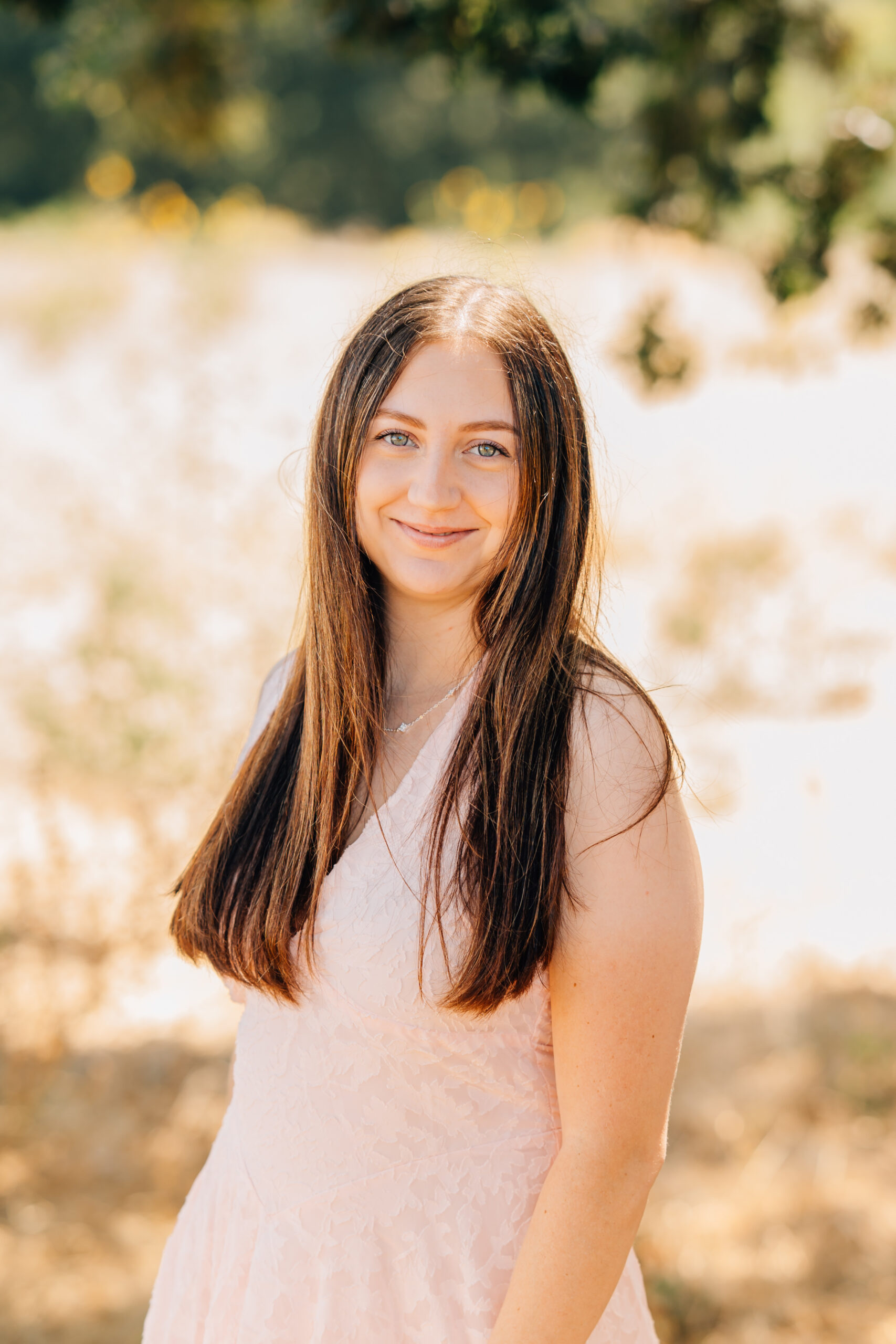 Portrait of a woman in a light pink dress during an extended family shoot. 